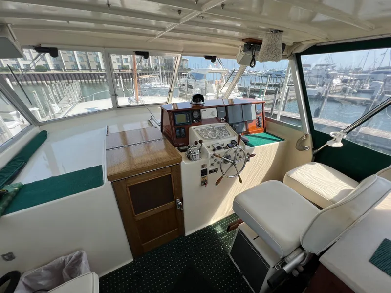 Slide: The Image of 1967 Hatteras 41 Twin Cabin helm with vintage controls and marina view. - 16