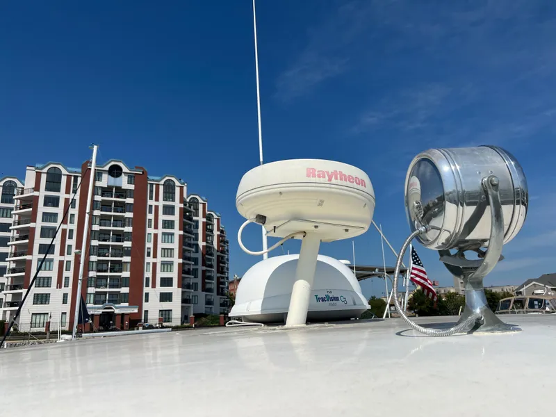 Slide: The Image of 1967 Hatteras 41 Twin Cabin boat with radar equipment, docked near modern buildings. - 18