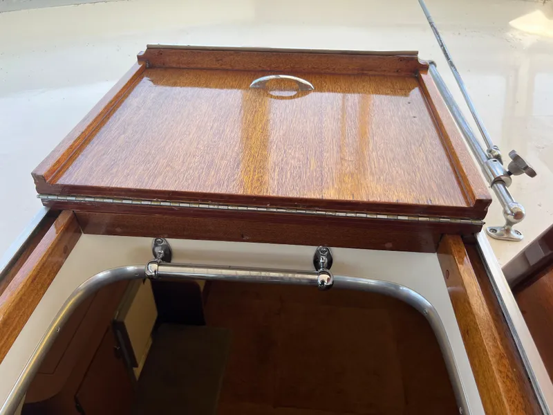 Slide: The Image of Wooden hatch of 1967 Hatteras 41 Twin Cabin boat, featuring polished finish and metal handle. - 24