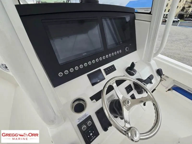 Slide: The Image of Control panel of 2025 Regulator 31 boat with dual screens and steering wheel. - 10