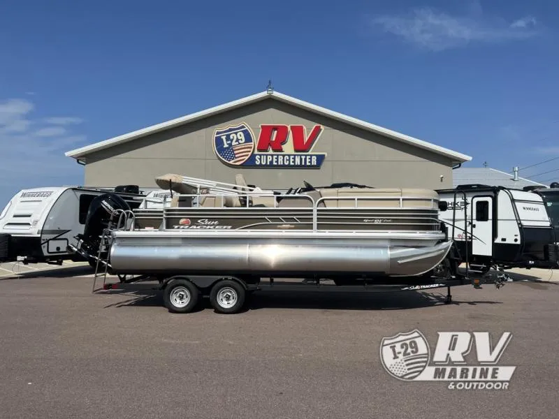 Slide: The Image of 2023 Sportfish 20 DLX pontoon boat at RV Supercenter, parked on a trailer. - 1