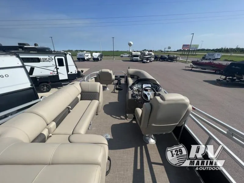 Slide: The Image of 2023 Sportfish 20 DLX pontoon boat with beige seating, parked at RV Marine dealership. - 20