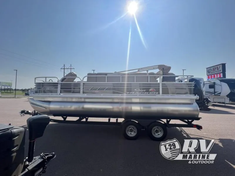Slide: The Image of 2023 Sportfish 20 DLX pontoon boat on trailer under bright sun at RV Marine dealership. - 3