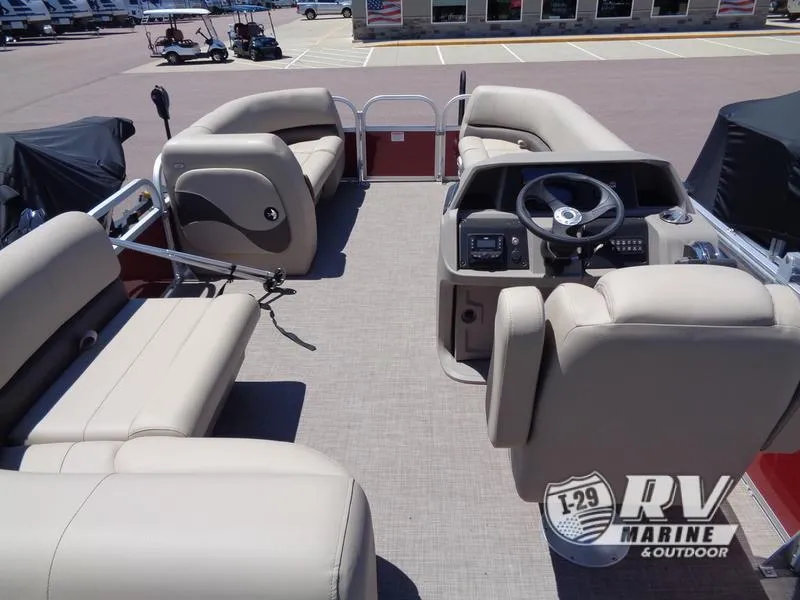 Slide: The Image of 2024 Party Barge 18DLX pontoon boat interior with beige seating and steering console. - 13