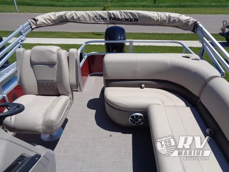 Slide: The Image of 2024 Party Barge 18DLX pontoon boat with beige seating and steering console. - 15