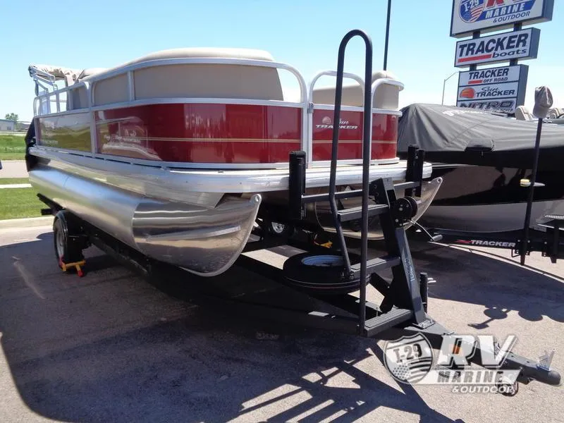 Slide: The Image of 2024 Party Barge 18DLX pontoon boat on trailer at dealership. - 4