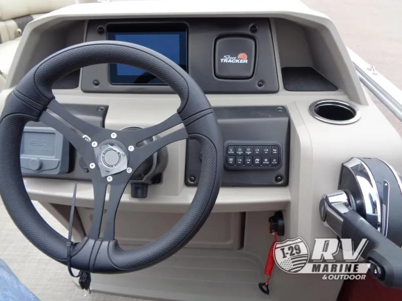 Slide: The Image of 2024 Party Barge 20 steering console with controls and display. - 22