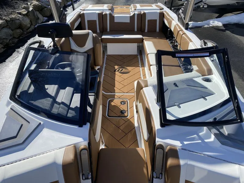 Slide: The Image of 2025 Malibu 23 LSV boat interior with tan and white seating, open windshield. - 17