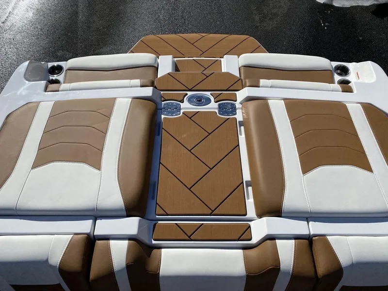 Slide: The Image of 2025 Malibu 23 LSV boat interior with brown and white cushioned seating. - 19