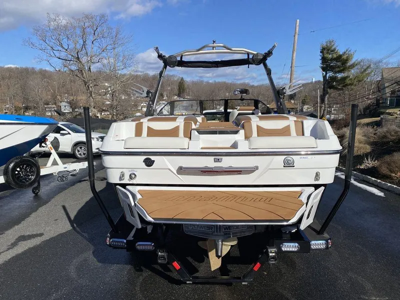 Slide: The Image of 2025 Malibu 23 LSV boat, rear view, parked outdoors on a sunny day. - 5