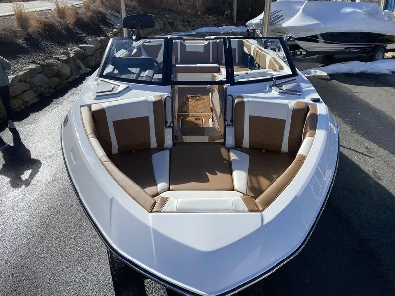 Slide: The Image of 2025 Malibu 23 LSV boat with sleek design and spacious seating in a sunny outdoor setting. - 9