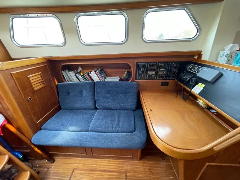 Slide: The Image of Interior of 1984 Belliure Sloop with blue seating, wooden paneling, and navigation equipment. - 7
