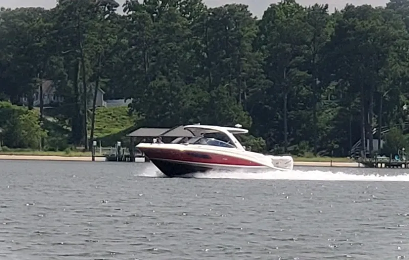 Slide: The Image of 2017 Sea Ray 350 SLX cruising on a lake with lush green trees in the background. - 19