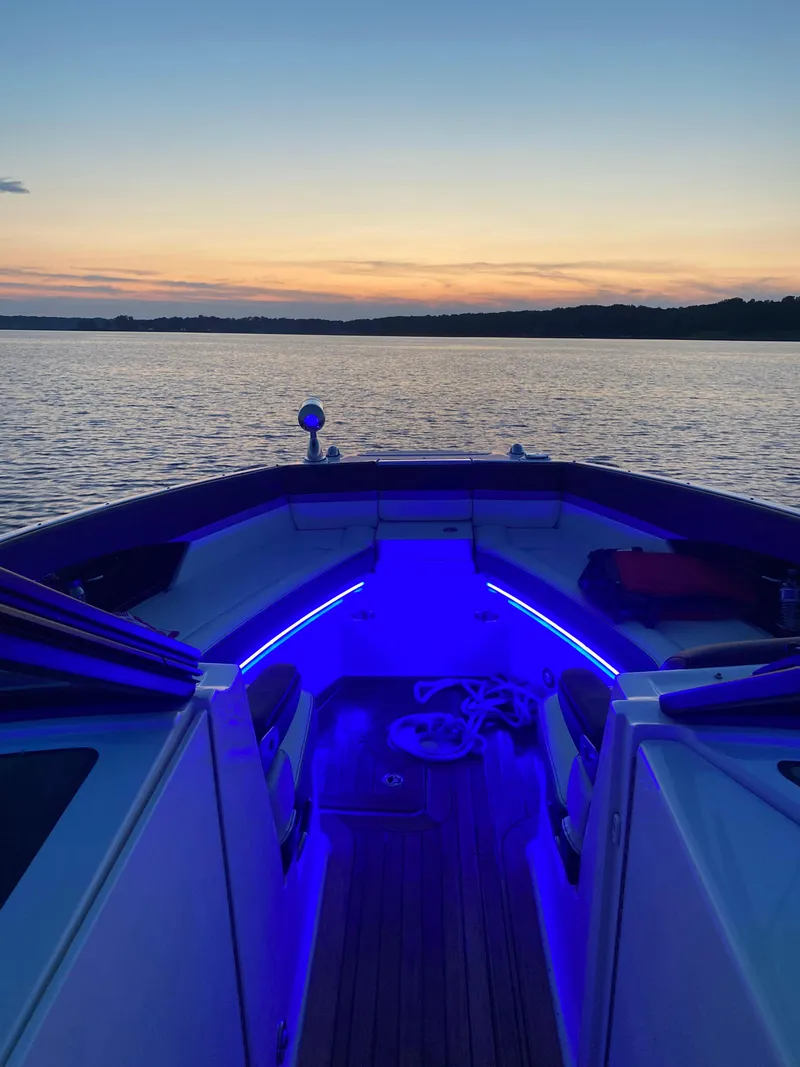 Slide: The Image of 2017 Sea Ray 350 SLX boat with blue interior lights at sunset on a calm lake. - 24