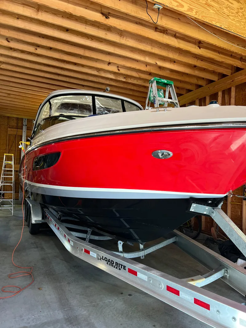 Slide: The Image of 2017 Sea Ray 350 SLX boat in storage, vibrant red hull, on a trailer. - 25