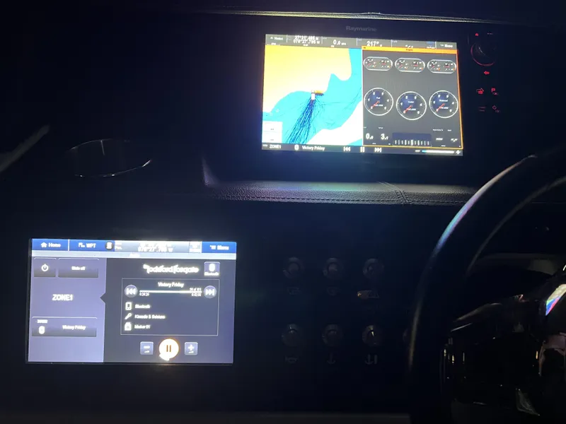 Slide: The Image of Dashboard of a 2017 Sea Ray 350 SLX with navigation and control screens. - 28