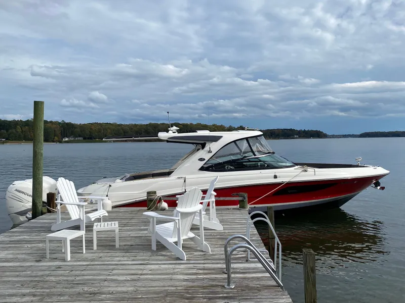 Slide: The Image of 2017 Sea Ray 350 SLX boat docked by a wooden pier with chairs. - 31