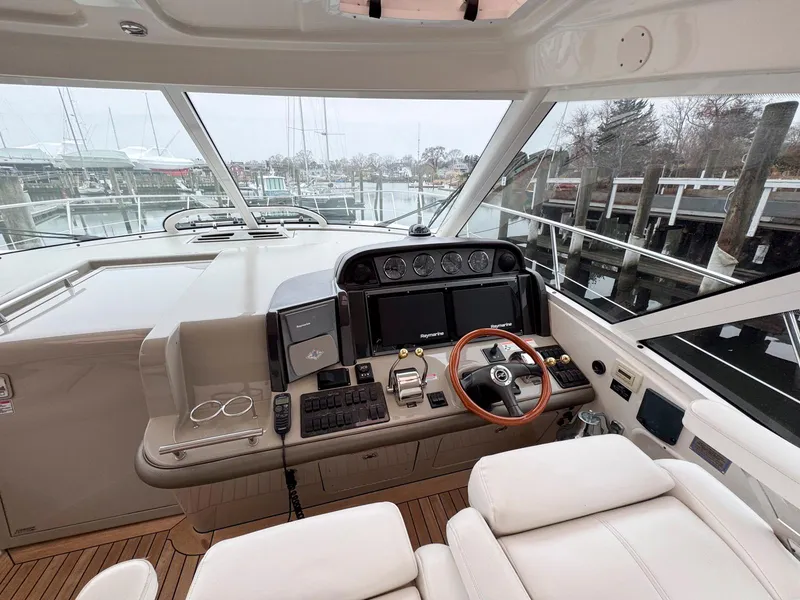 Slide: The Image of 2006 Sea Ray 48 Sundancer helm with modern controls and wooden steering wheel. - 10