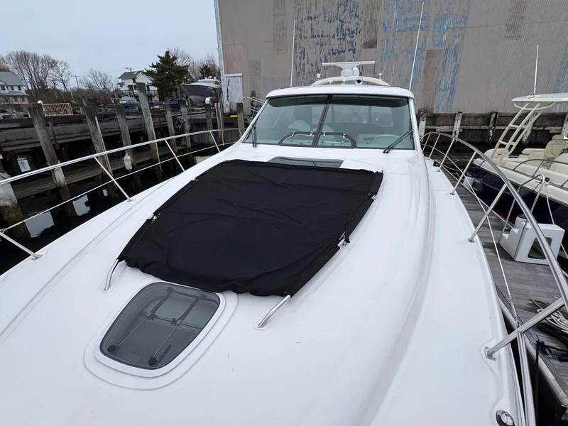 Slide: The Image of 2006 Sea Ray 48 Sundancer yacht docked, featuring sleek design and covered deck. - 11