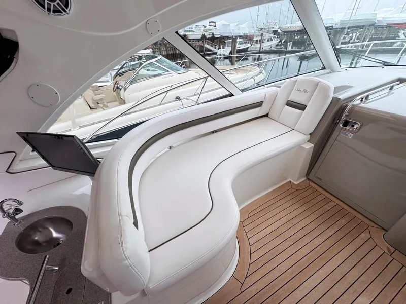Slide: The Image of Luxurious 2006 Sea Ray 48 Sundancer yacht interior with white seating and wood flooring. - 6