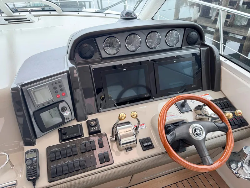 Slide: The Image of 2006 Sea Ray 48 Sundancer helm with advanced navigation controls and wooden steering wheel. - 9