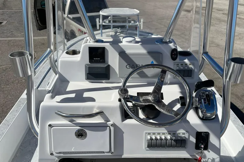 Slide: The Image of 2018 Shallow Sport 25 X3 boat dashboard with steering wheel and controls. - 13