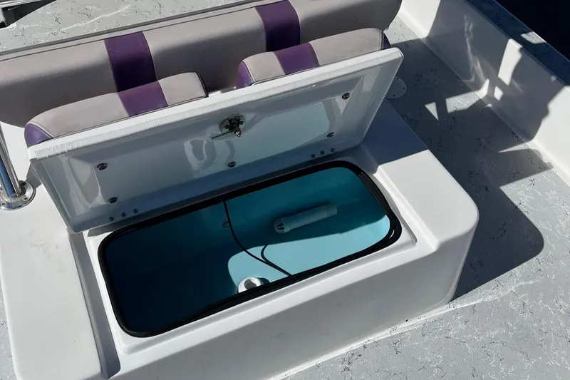 Slide: The Image of 2018 Shallow Sport 25 X3 boat with open storage compartment and cushioned seating. - 18