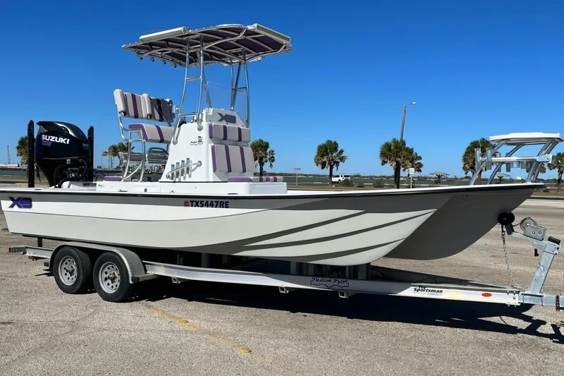 Slide: The Image of 2018 Shallow Sport 25 X3 boat on trailer with Suzuki engine, parked outdoors. - 3