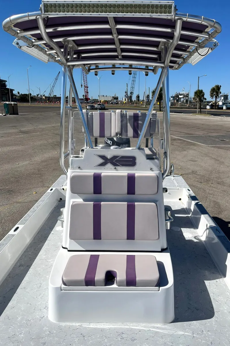 Slide: The Image of 2018 Shallow Sport 25 X3 boat with purple-striped seating and T-top canopy. - 9