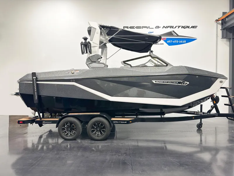 Slide: The Image of 2025 Nautique Super Air Nautique G21 boat on trailer in showroom. - 1