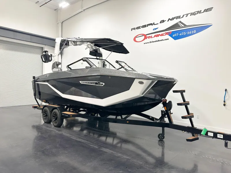 Slide: The Image of 2025 Nautique Super Air Nautique G21 boat on trailer in showroom. - 2