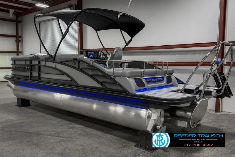 Slide: The Image of 2025 Bennington 23 RSB pontoon boat with canopy in a warehouse setting. - 11