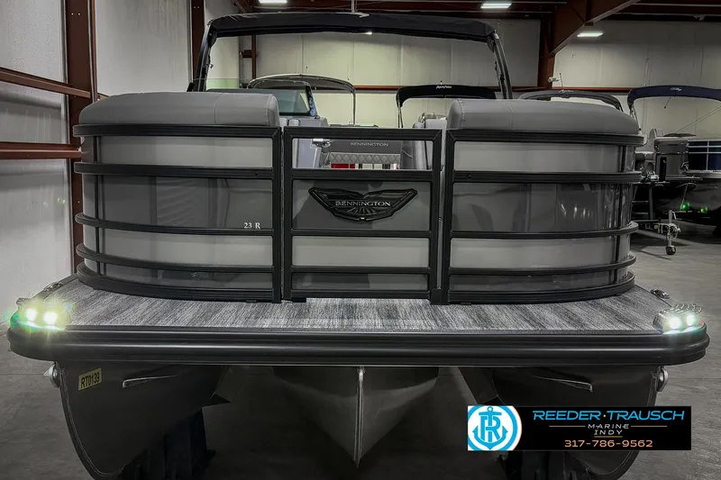 Slide: The Image of 2025 Bennington 23 RSB pontoon boat in showroom, front view with logo and lights. - 13
