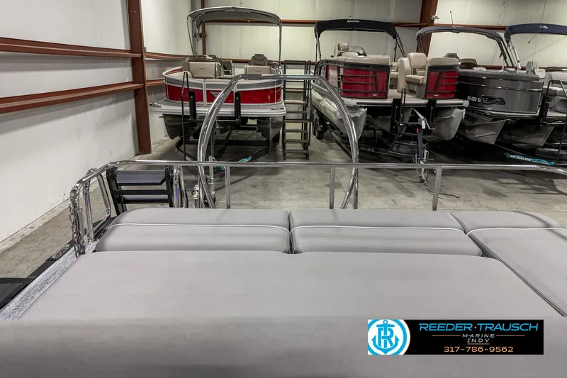 Slide: The Image of 2025 Bennington 23 RSB pontoon boats in showroom, Reeder-Trausch Marine logo visible. - 20