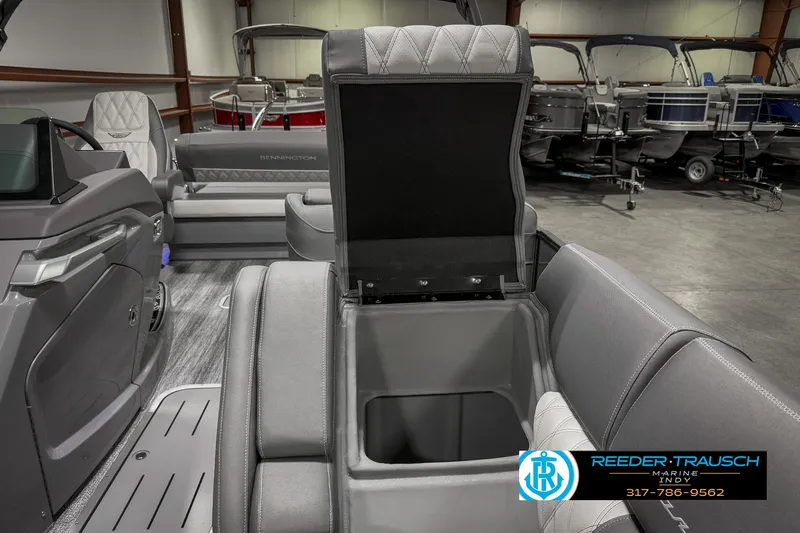 Slide: The Image of 2025 Bennington 23 RSB boat interior with open storage compartment, gray seating, showroom display. - 29