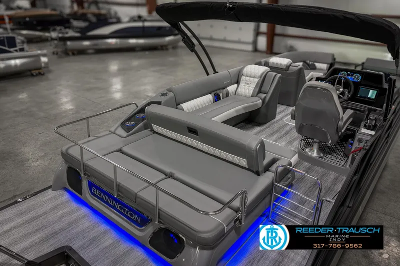 Slide: The Image of 2025 Bennington 23 RSB pontoon boat with luxurious seating and modern dashboard in showroom. - 33