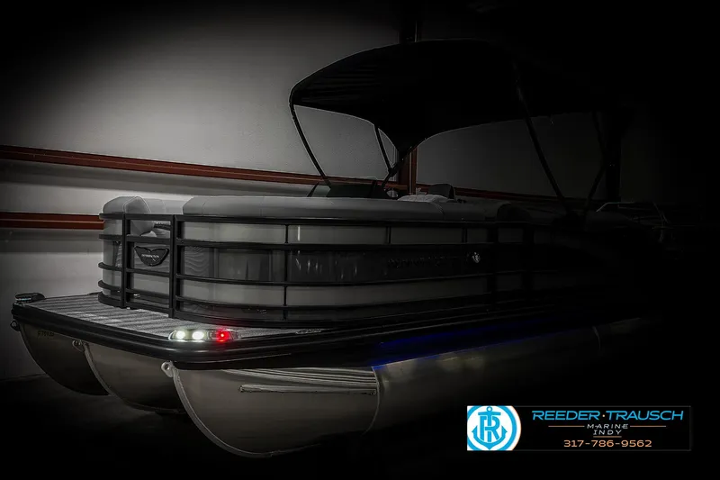 Slide: The Image of 2025 Bennington 23 RSB pontoon boat in showroom with canopy and logo. - 9