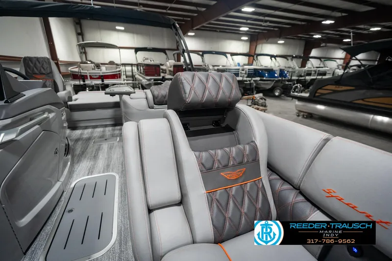 Slide: The Image of 2025 Bennington 23 RSB luxury boat interior with plush seating in showroom. - 23