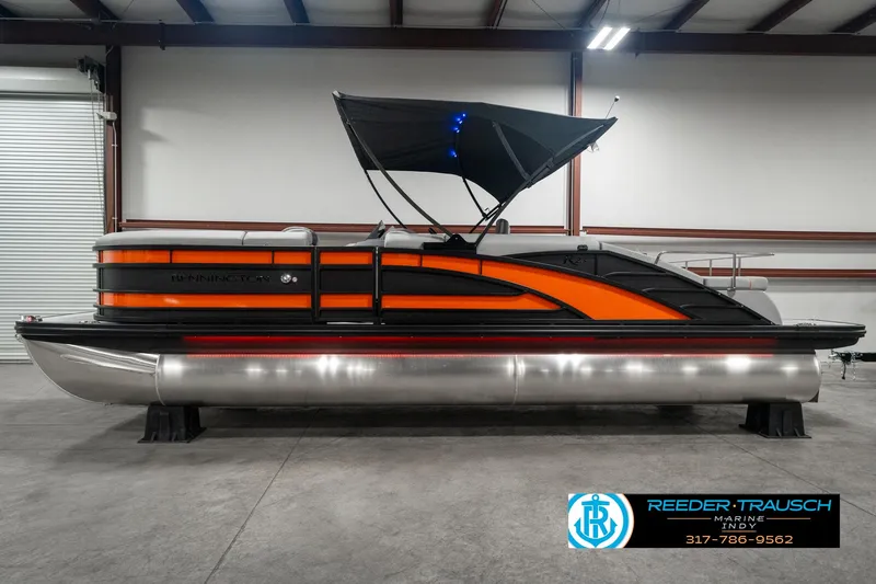 Slide: The Image of 2025 Bennington 23 RSB pontoon boat with orange and black design in showroom. - 5