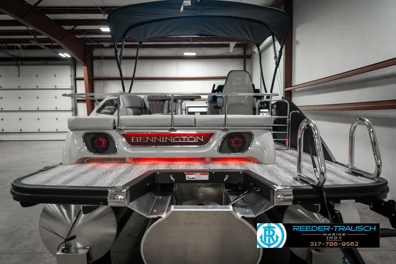 Slide: The Image of 2025 Bennington 23 RSB pontoon boat in showroom, rear view with logo and seating. - 7