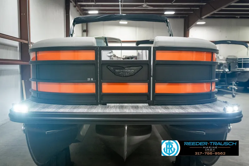 Slide: The Image of 2025 Bennington 23 RSB pontoon boat with orange accents in a showroom. - 8