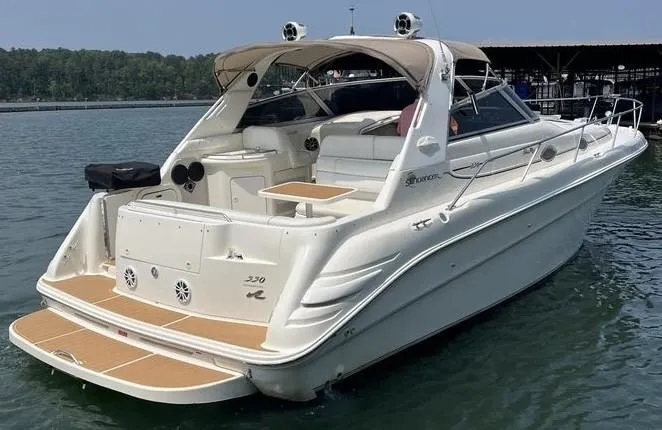 Slide: The Image of 1996 Sea Ray 330 Sundancer boat on water, featuring spacious deck and seating area. - 1