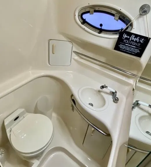 Slide: The Image of 1996 Sea Ray 330 Sundancer bathroom with sink, toilet, and porthole window. - 4