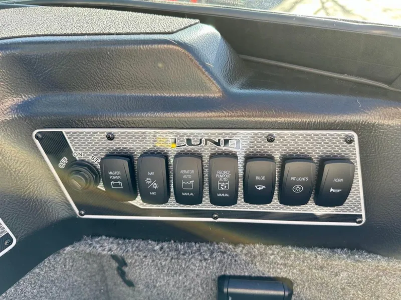 Slide: The Image of Control panel of 2025 Lund 1775 Impact XS Sport boat with labeled switches. - 14