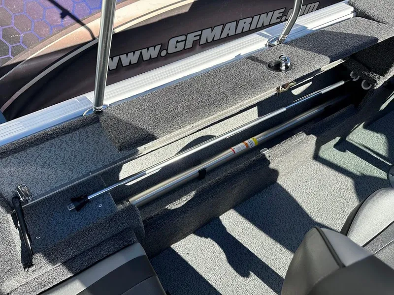 Slide: The Image of 2025 Lund 1775 Impact XS Sport boat interior with rod storage and carpeted flooring. - 19