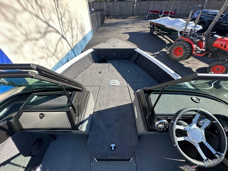 Slide: The Image of 2025 Lund 1775 Impact XS Sport boat interior with steering wheel and seating area. - 21