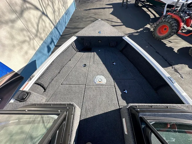 Slide: The Image of 2025 Lund 1775 Impact XS Sport boat interior with carpeted deck and storage compartments. - 22