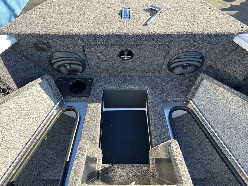 Slide: The Image of 2025 Lund 1775 Impact XS Sport boat interior with storage compartments and speakers. - 25