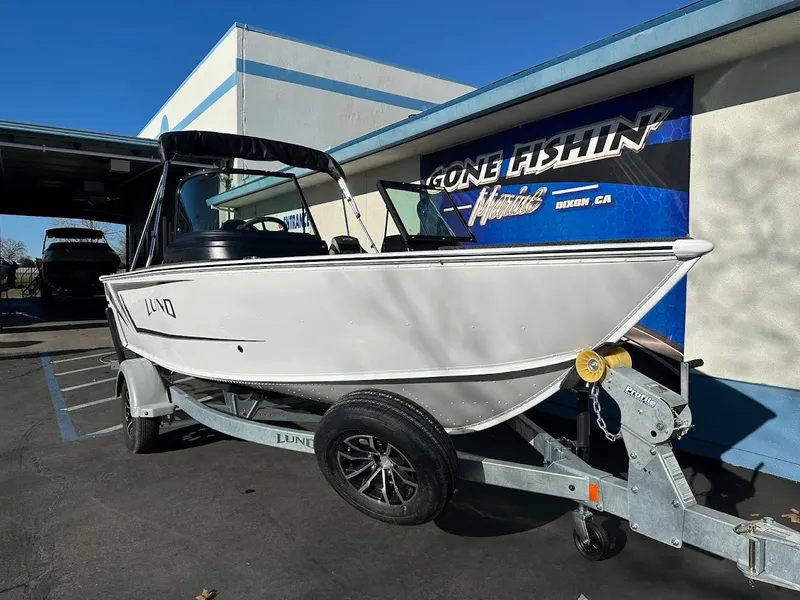 Slide: The Image of 2025 Lund 1775 Impact XS Sport boat on trailer, parked outside a building. - 4