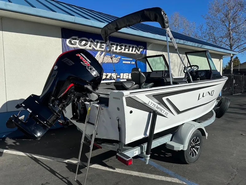 Slide: The Image of 2025 Lund 1775 Impact XS Sport boat on trailer, parked outdoors. - 6